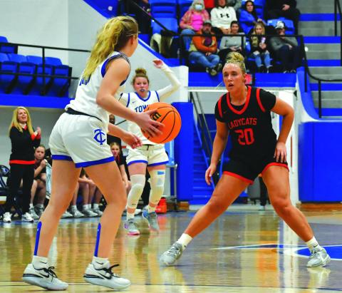 Wade Cheek/The Clayton Tribune. With head coach DeeDee Dillard watching on the left, senior Lady Cat Ellie Southards plays defense against Towns County in December.