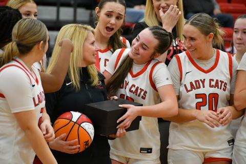 Wade Cheek/The Clayton Tribune. RCHS basketball players surround and celebrate their head coach DeeDee Dillard at mid-court following her 400th career victory as head coach of the Lady Cats.