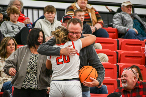Wade Cheek/The Clayton Tribune. After giving him the game ball from her 1,000th career point, Rabun County Lady Cat senior Ellie Southwards hugs her father Gabe Southarsds in the stands on Jan. 13 at home in Tiger.