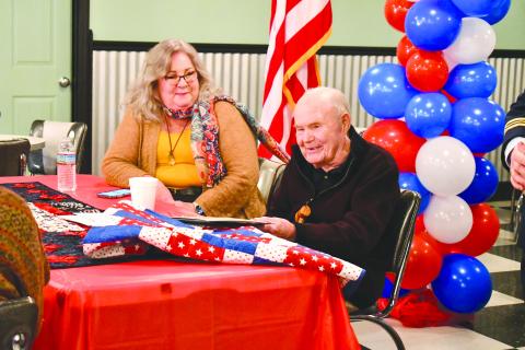 Megan Horn/The Clayton Tribune. WWII U.S. Navy veteran Lt. J.G., Dr. Eldred Causey smiles alongside his daughter Kathy Causey as he is recognized at the Vet to Vet Cafe Feb. 13 for turning 100 years old. He received gifts for his milestone birthday. 