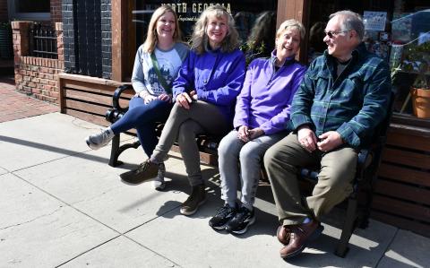 Megan Horn/The Clayton Tribune. DDA members Sonya Shook, Co-Chair Karen Bacon, Chair Cassandra Clouser and Chester Baumgartner enjoy conversing on one of the convenient new benches located on Main Street in downtown Clayton. There are now a total of seven benches in the downtown area. Not pictured are fellow DDA members Trey Sanders and Althea Bleckley. 