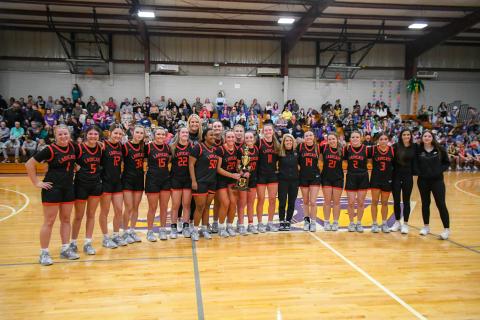 Wade Cheek/The Clayton Tribune. The RCHS girls basketball team stands together with championship hardware after its 57-47 region title victory over Athens Christian. 