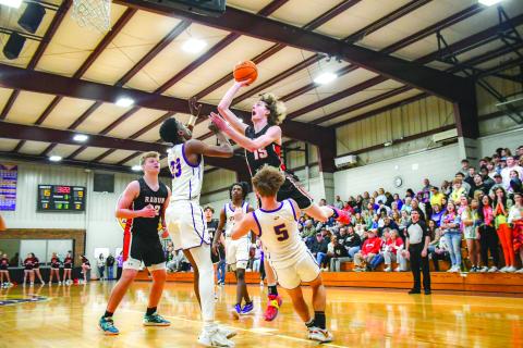 Wade Cheek/The Clayton Tribune. Wildcat basketball sophomore Hayes Free elevates over multiple Athens Christian defenders, drawing a foul, during the Feb. 16 Region 8 championship game. The Wildcats fell to the region champ Eagles.