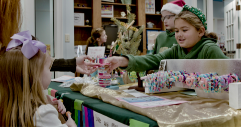 Submitted photo. Rabun Gap-Nacoochee School hosted its third annual Second Grade Marketplace on Tuesday, Dec. 12, where students learned entrepreneurship and economics while raising money for a community garden. Pictured, Blake Ruiz, Class of 2034 of Otto, N.C., interacts with a customer on market day.