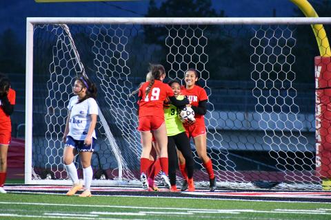 Wade Cheek/The Clayton Tribune. RCHS girl soccer players celebrate with Lady Cat goalkeeper Alesia Gonzalez after she earned a save against Elbert County on Wednesday, Feb. 28. The Lady Cats won 8-1 for their second-straight region win. 