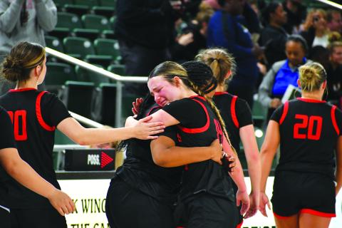 Wade Cheek/The Clayton Tribune. RCHS junior guard Jacie McCall hugs senior Isia Wilmont after the emotional loss to Galloway on March 1 that eliminated the Lady Cat basketball team from the state tournament. 