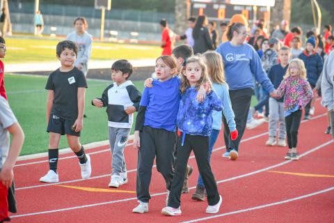 Wade Cheek/The Clayton Tribune. Youth soccer Lady Cats Juliette Pitassi (left) and Reeves Bragg walk arm-in-arm around Frank Snyder Memorial Stadium as part the March 19 “Rec Night” in between the RCHS girls and boys soccer games. 