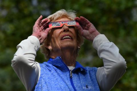 File/Enoch Autry/The Clayton Tribune. Dottie Haney of Sky Valley uses her solar viewing glasses to look at the solar eclipse while at Black Rock Mountain State Park on Oct. 11, 2023. 