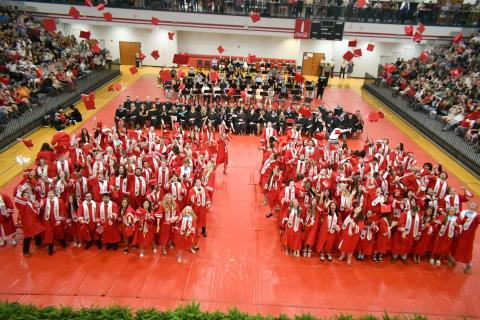 Wade Cheek/The Clayton Tribune. The members of the Class of 2024 from Rabun County High School toss their caps into the air inside the campus gym upon graduation.