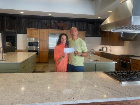 Submitted photo. Abby Jackson hands a donation check of $1,500 to James Brim, director of the Food Bank of Northeast Georgia Mountain Branch, for summer creative cooking classes for children. The Teaching Kitchen is presenting “Creative Cooking: Learning to Use What’s In Your Kitchen!” in June and July. 