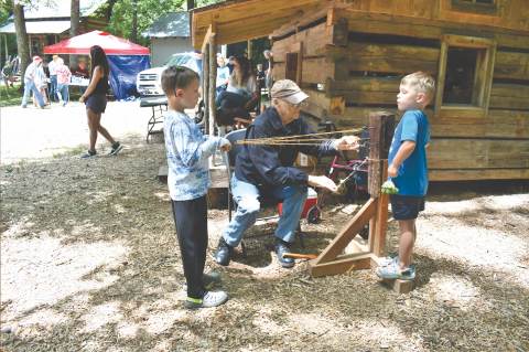 Megan Horn/The Clayton Tribune.  Kermit Rood demonstrates rope making at Foxfire Heritage Days last weekend to youngsters Archer Reinhardt, 8; and Brandt Reinhardt, 6. The event was held June 7 and 8  in Mountain City during the 50th anniversary of the beginning of the Foxfire Museum. Heritage Days continue to grow.