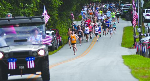 Enoch Autry/The Clayton Tribune. Eventual 5K winner Luke Napier leads the 909 participants at the beginning of the July 6 Rabun Ramble on Lake Rabun Road. The annual Independence Day event has its largest-ever turnout. 