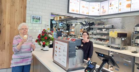 Megan Horn/The Clayton Tribune. Customer Linda Bradley with team member Kourtney. Below: Those who order from the Chick-fil-A mobile app can go through the right “mobile-thru” lane at the restaurant and scan a QR code to obtain their order. 