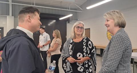 Megan Horn/The Clayton Tribune. Rabun County Schools Superintendent Dr. April Childers mingles with school officials, community leaders and board of education members during her retirement reception at the Rabun County Agricenter Tuesday. Pictured are Tony Penrose (left), Childers and Kathy McClure. Childers officially retires Sept. 30 and Steven Cole will become the full-time superintendent. Below: Rabun County Schools Superintendent Dr. April Childers converses with Mickey Duvall during her reception.
