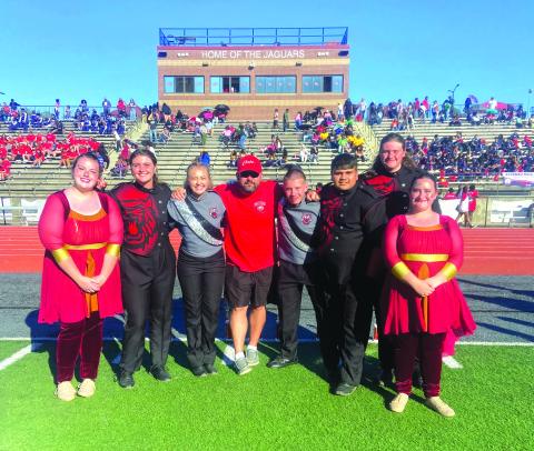 Following the Jaguar Classic, Lillian Seabolt, color guard captain; Lilly Padgett, drumline captain; Ashleigh Lewis, head drum major; Matthew Leff, RCHS director of bands; Jaden Horner, assistant drum major; Maxi Barrientos, band captain; Brady Mazarky, drumline captain; and Abby Streetman, color guard captain pose for a group photo.