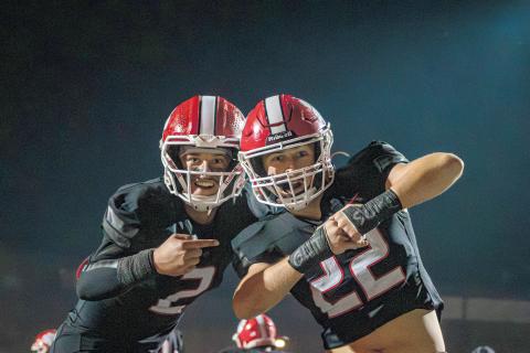 Wade Cheek/The Clayton Tribune. Rabun County quarterback Ty Truelove points out a message on teammate Carver Jarrard’s wrists of “Get Some” during the Wildcats’ regular-season game against Elbert County. RCHS plays Fitzgerald Friday.