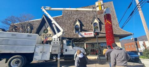 Megan Horn/The Clayton Tribune. City of Clayton workers spend hours on Monday installing the iconic candle atop Reeves at the intersection of Main Street and East Savannah Street. Santa Claus will light the candle on Saturday, Dec. 7, at the end of the parade. 