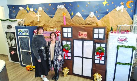 Megan Horn/The Clayton Tribune. Casidi Collins and Hayleigh Gosnell, tellers at My Georgia Credit Union in Clayton, are excited about their holiday decoration detailing popular Main Street businesses. The detailed display won them first place in the annual decorating contest held among the eight branch locations.  