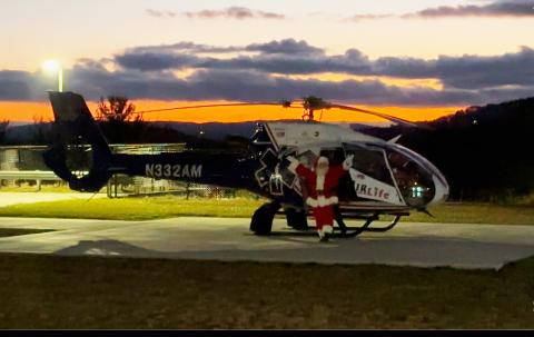 Photo courtesy Mountain Lakes Medical Center. With the sunset in the background, Santa exits an AirLife helicopter at Mountain Lakes Medical Center to visit local youth on Dec. 19.