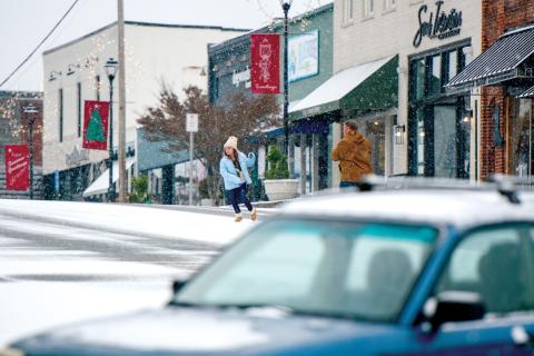 Wade Cheek/The Clayton Tribune. Families used the opportunity to get photos as the snow fell in downtown Clayton.