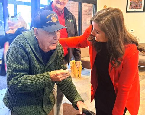Megan Horn/The Clayton Tribune. Carolyn Culpepper with Family Hospice greets WWII U.S. Navy veteran Lt. J.G. Dr. Eldred Causey at the Vet-to-Vet Café for his 101st birthday on Feb. 11. Culpepper presented him with his button that has his motto, “Go with the Flow.” 