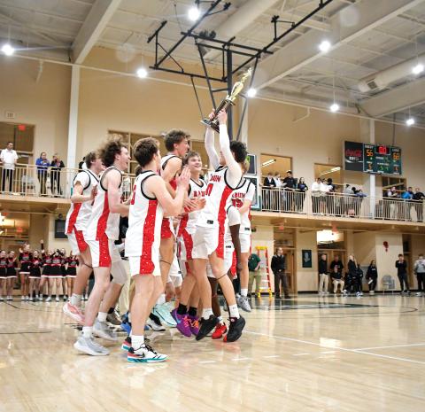 Wade Cheek/The Clayton Tribune. The Rabun County High School boys basketball team celebrates and hoists their region championship trophy after defeating Commerce High School 68-56 on Friday, Feb. 14. The second-seeded Wildcats were scheduled to host No. 31 Social Circle in the state tournament on Wednesday, Feb. 19. 