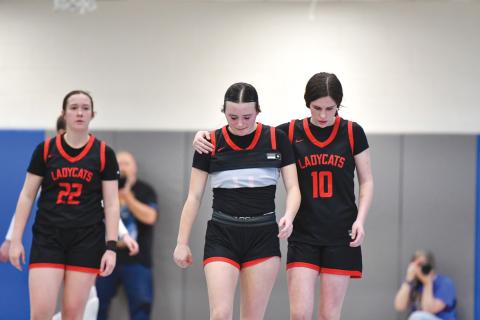 Wade Cheek/The Clayton Tribune. Sophomore Morgan Lovell hugs her senior teammate Jacie McCall after the Lady Cats fell 71-35 in the class A-DI quarterfinal against Banks County. 