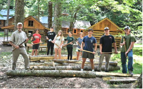 File/Megan Horn/The Clayton Tribune. Local students participated in the 2023 Foxfire Summer Leadership Program, now called “Project Foxfire,” where they helped Foxfire Museum Director Barry Stiles hew logs to build the miniature replica Blacksmith Shop, which is now featured in the Children’s Village. Students pictured from the 2023 program include Luke Thompson, Sam Flaherty, Celton Littrell, Sean Flaherty, Brinn Justice, Gavin Sharpe, Lily Karplus and Olivia Nixon. 