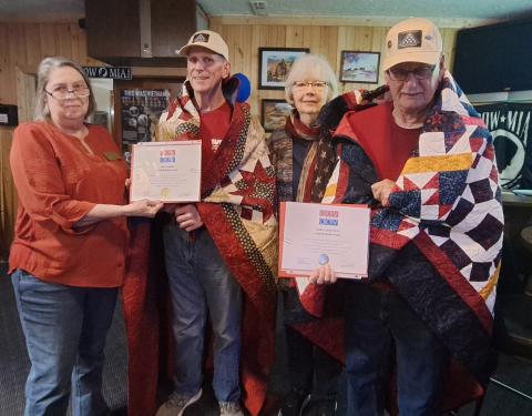 Megan Horn/The Clayton Tribune. United States Army Veterans and locals Gary Cantwell and Jon Jones are awarded Quilts of Valor by Karen Trombley, Georgia State Coordinator, and Sharon Ruth with Quilts of Valor during a special presentation at the VFW Post 4570 Friday, Feb. 28. Pictured are Trombley (left) Jones, Ruth and Cantwell. 