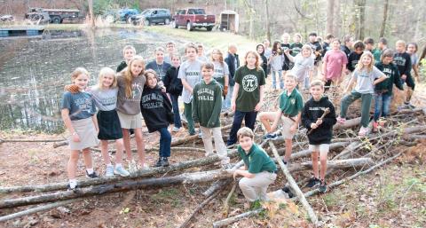 Photo courtesy of Tallulah Falls School. Tallulah Falls School fourth and fifth graders show off the pile of debris they collected during the clean up project.