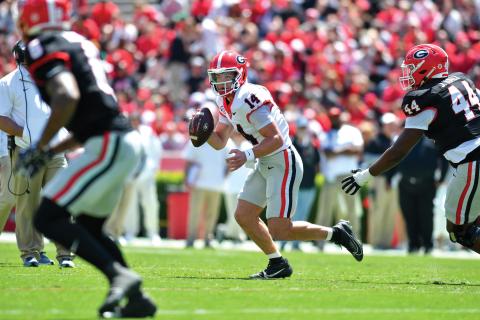 Wade Cheek/The Clayton Tribune.  Gunner Stockton evades pressure from his own Bulldog teammates in Georgia’s spring game last weekend. Stockton led his red team to a 34-17 win over the opposing black team and fellow quarterback Ryan Puglisi. 