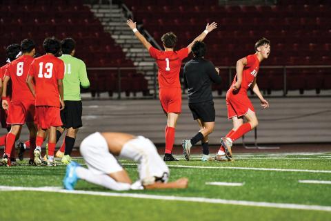 Wade Cheek/The Clayton Tribune. The Rabun County boys soccer team celebrates a second-round 1-0 playoff win over Temple as the Tigers mourn the end of their season. With the victory, the Wildcats advanced to the state quarterfinals.