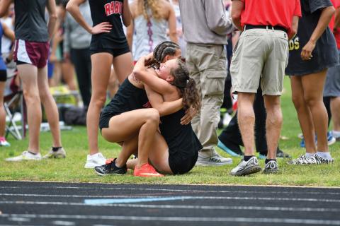 Wade Cheek/The Clayton Tribune. Arabella Nepa (left) hugs Lindsay Whitmire (right) after Whitmire finished her leg of the girls 4x800m relay at state sections in Bremen. The girls relay team squeaked into the state championship meet after Whitmire clinched the last spot with a lean into the finish line. 