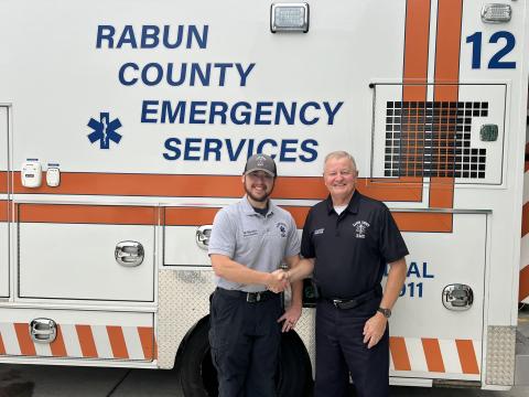 Photo courtesy Rabun County EMS. Will Shanks (left) is Rabun County Emergency Services’ newest Nationally Registered Paramedic. Rabun County EMS/911 Director Mike Carnes congratulates Shanks and shakes his hand. 