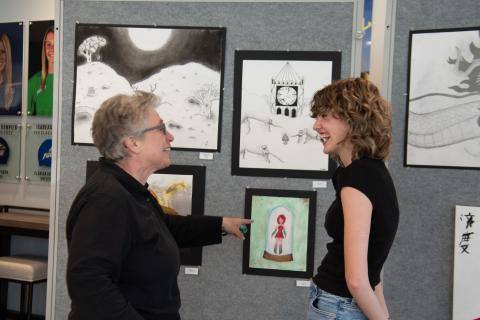 Submitted photo. :TFS sophomore Olivia Bonner shows middle school counselor Elizabeth Kyle a piece of her artwork at the Evening of the Arts.