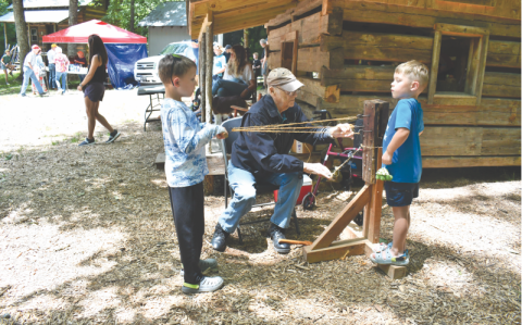 File/Megan Horn/The Clayton Tribune. Kermit Rood demonstrates rope making to youngsters Archer Reinhardt, 8; and Brandt Reinhardt, 6, at last year’s Foxfire Heritage Days event. 