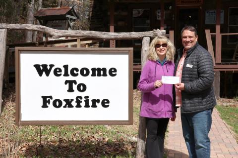 Megan Horn/The Clayton Tribune. Karen Bacon, Rotary Club of Clayton Foundation chair (left), presents Foxfire Executive Director Todd Faircloth with proceeds in March to help fund the removal of trees on the Foxfire property. 