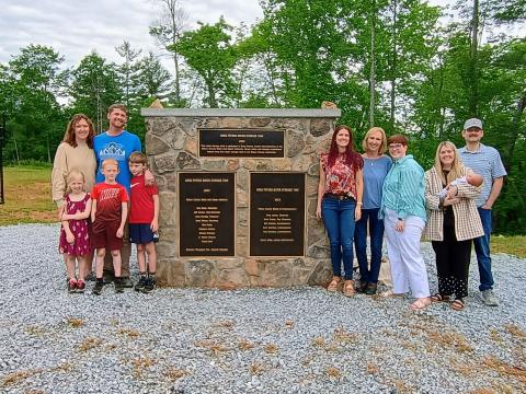 Megan Horn/The Clayton Tribune. Community members attended a dedication ceremony of the 750,000-gallon, ground-level water storage tank located on Yorkhouse Road in Rabun Gap. Pictured are Peters’ family members including Sarah Peters, Joel Peters, Joanna Radford, Susan Peters, Jennifer Peters, Jaimie Crane holding Susie in her arms, John Crane, Eloise Peters, Xander Peters and Tatham Peters. 