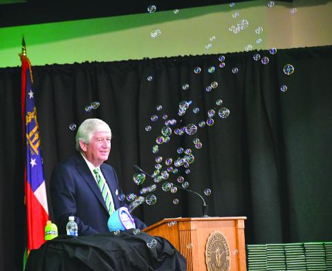 Enoch Autry/The Clayton Tribune. Graduation speaker Dink NeSmith, co-owner of Community Newspapers, Inc., utilizes a soap bubble machine during his speech, noting how bubbles are like dreams. NeSmith told the Tallulah Falls School graduates to remember a “no” can be a stumbling block or it can be a stepping-stone in their path to making their dreams come true.