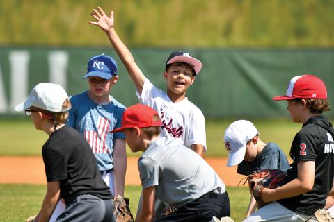 Wade Cheek/The Clayton Tribune. Aiden Terrell waves to the camera during the TFS kids baseball camp on Wednesday, June 11. 
