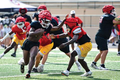 Wade Cheek/The Clayton Tribune. Junior running back/linebacker Jakaden Shiflet breaks the tackle of a Clarke Central defender at Buford High School’s padded camp on Wednesday, June 18. 