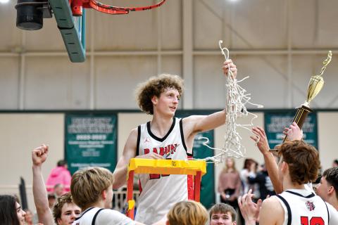 Wade Cheek/The Clayton Tribune. Rabun County post Hayes Free hoists up the net after the Wildcats won the 8A-DI region title over Commerce High School last season. 
