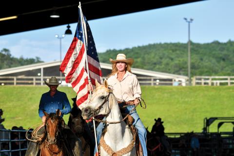 Wade Cheek/The Clayton Tribune. Mille Whitehead rides into the Rabun Arena with the American flag.