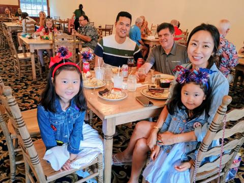 Megan Horn/The Clayton Tribune.  It was family fun at The Dillard House on July 4 for annual Independence Day celebrations. The Dillard House has been celebrating the tradition for decades. Pictured enjoying their buffet meal are Emmy Lim, 6; David Lim; John Dillard, Legacy Ventures and Manager of The Dillard House; Stella Lim; and Colette Lim, 4, dressed in patriotic attire as they enjoy the festivities. 