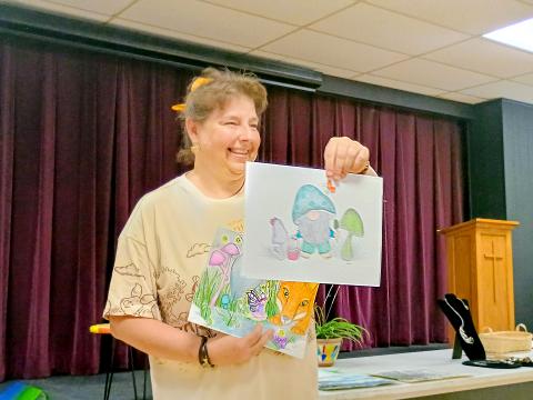 Megan Horn/The Clayton Tribune.  Gretchen Roach displayed her mixed-medium illustrations featuring fairies and gnomes during the Guild’s “Members’ Show and Tell” program July 17. She said her focus is to produce something positive in her creations. 