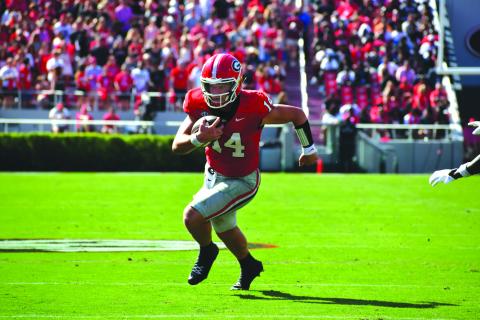 Wesley Branch/The Clayton Tribune. Georgia quarterback Gunner Stockton runs for extra yards for the Bulldogs. Stockton will have his Rabun County jersey retired on Friday, Sept. 19.