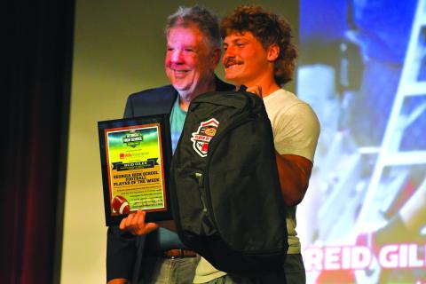Wesley Branch/The Clayton Tribune. Rabun County senior Reid Giles and Georgia High School Football Daily marketing director Ted Langford pose together after Giles receives his “Player of the Week” plaque on Sept. 10 at Rabun County High School.