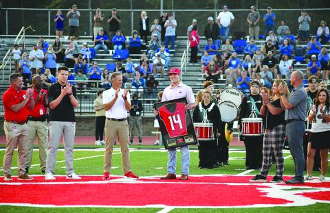Enoch Autry/The Clayton Tribune. Gunner Stockton holds his newly retired No. 14 Rabun County Wildcat jersey during a Sept. 19 pregame ceremony at midfield of Frank Snyder Memorial Stadium. The standout former RCHS quarterback, who still owns Georgia state football records, now is the starting QB for the University of Georgia. 