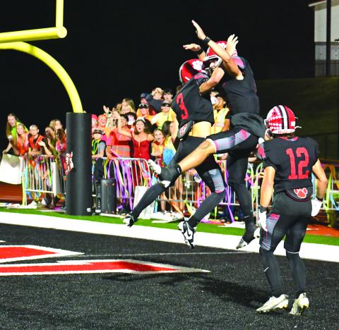 Enoch Autry/The Clayton Tribune. Rabun County senior quarterback Ty Truelove celebrates with freshman Cooper Kowalsky (3) after the signal caller runs 69 yards for a touchdown. The score by Truelove was his fifth TD of the night against Banks County in the Homecoming win. In the background, the RCHS student section cheers on their Wildcats. In the front is Hayden Bass, who was crowned as the 2025 Homecoming Queen at halftime.