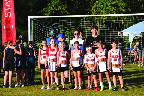 Submitted Photo. Rabun County Recreation Department cross country head coach Ed Eidson and assistant coach CJ Augustine pose for a photo with the 10U teams before the start of the race in Madison on Sept. 13.
